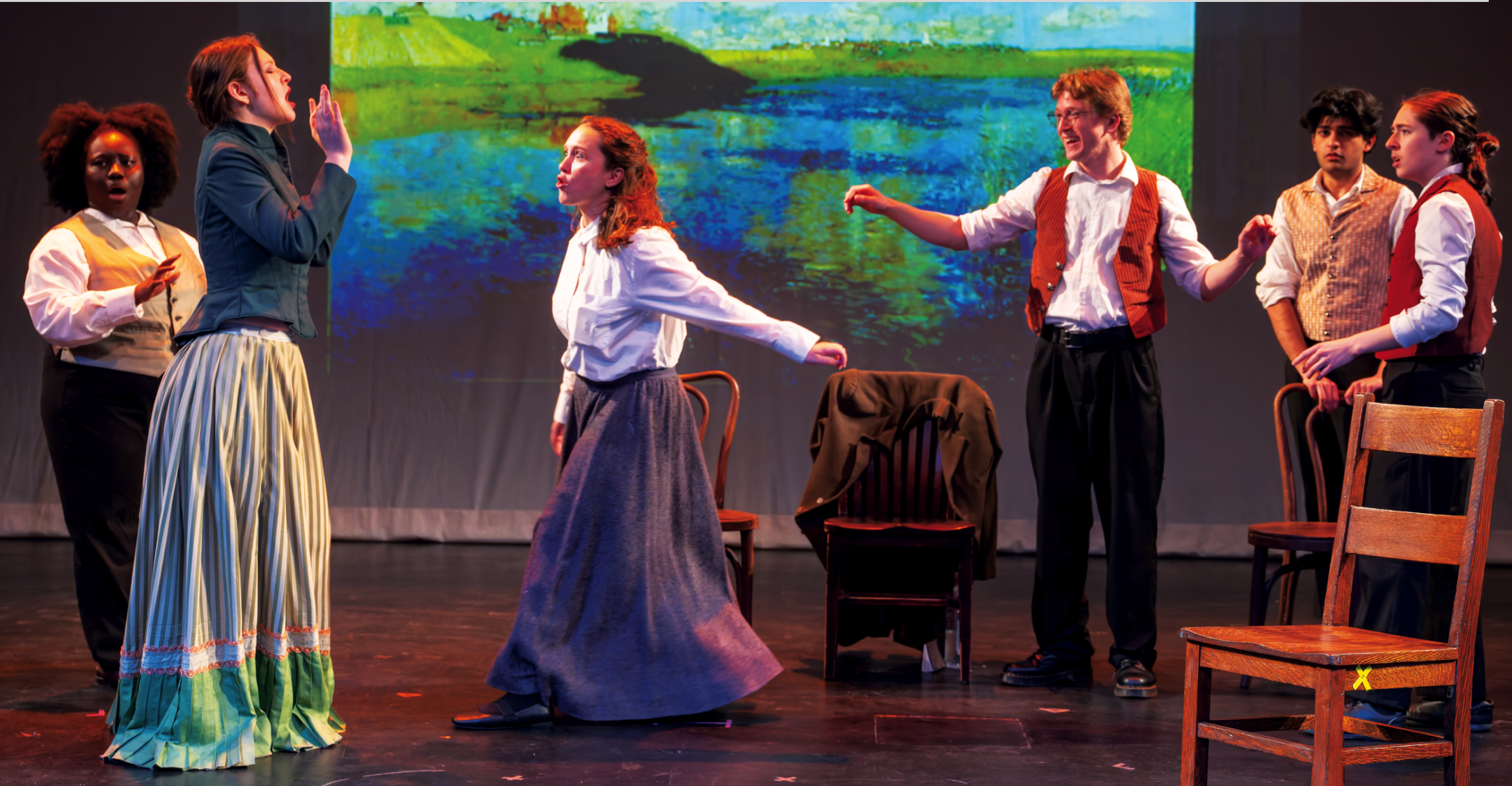 people on stage, chairs near 